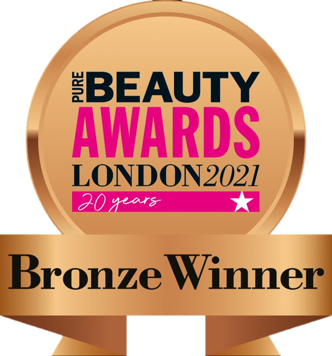 A logo for the Pure Beauty Awards London 2021. The logo is a bronze circular medal with the words "PURE BEAUTY AWARDS" in a mix of blue and pink font, with "LONDON 2021" and "20 years" below. A bronze ribbon hangs from the medal for Aviela Skincare with the text "Bronze Winner." The background is a black and gray checkered pattern, indicating transparency.