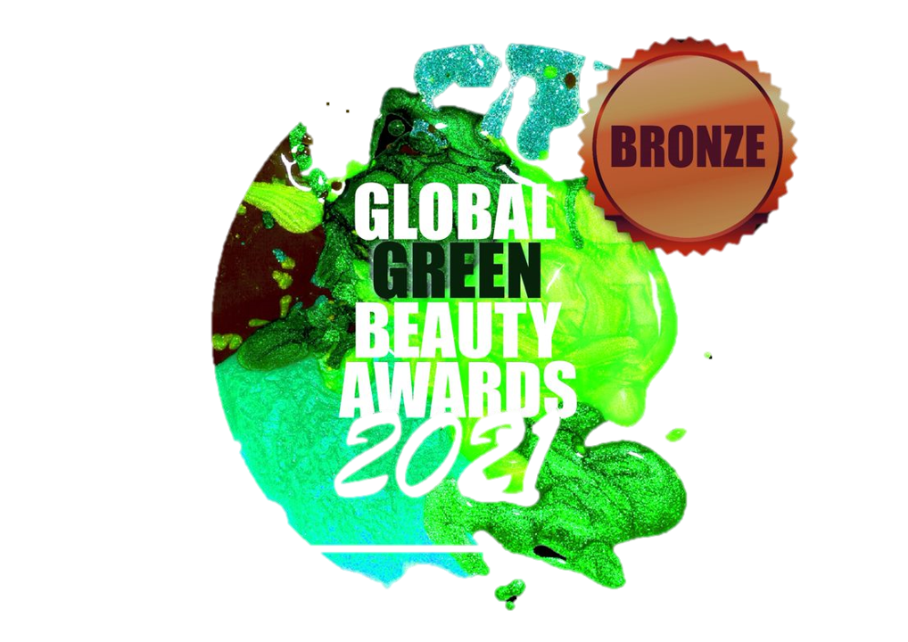A circular logo with a bronze seal on the top right. The logo features a green and turquoise design that resembles a planet with a dripping paint effect. The text "GLOBAL GREEN BEAUTY AWARDS 2021" is overlaid on the design. The background is a black and gray checkered pattern, indicating transparency.