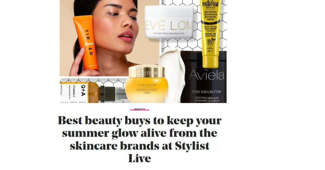 A cropped magazine spread with a headline that reads "Best beauty buys to keep your summer glow alive from the skincare brands at Stylist Live." The image features a model holding an orange tube of skincare product. Several products are arranged around her, including a jar of Aviela Pure Shea Butter with white text on a black background. Other products are also visible in the image.