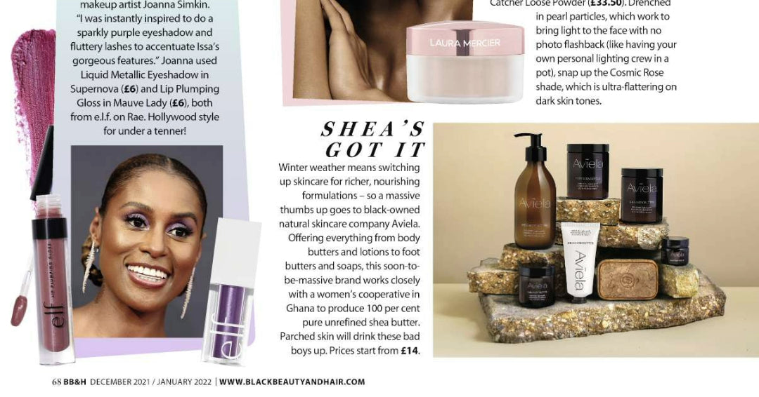 A photograph of various Aviela beauty products, including a pump bottle, jars of different sizes, a tube, and a bar of soap. The products are arranged on a series of stacked, rough-hewn stones against a light-colored background. To the left of the image is a short article titled "SHEA'S GOT IT" which praises the Aviela brand. The article describes the company as a natural skincare brand offering body butters, lotions, & soaps. It also mentions that the company works with a women's cooperative in Ghana.